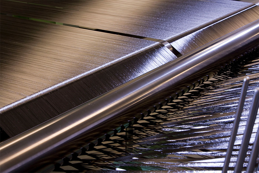 A metallic material being processed on a conveyor belt
