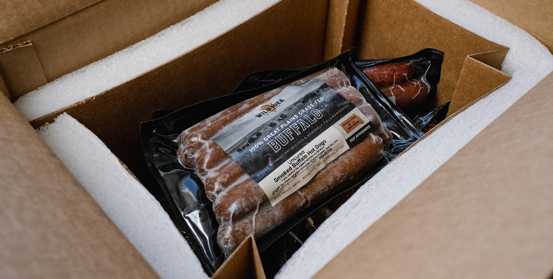 An insulated box of frozen sausages.