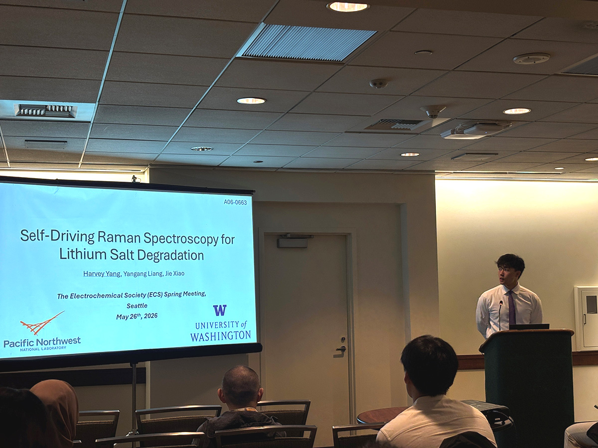 Harvey Yang stands at a lectern with his research displayed on a screen