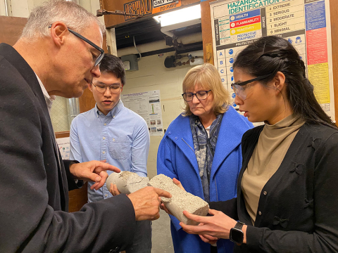 MSE master's students Kunthea Deng and Renjie Song show Gov. Jay Inslee and his wife, Trudi, how samples of zeolite concrete fractured in compression tests.