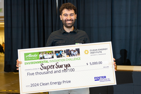 MSE junior Max Stafford holds up a giant novelty check made out to SuperSurya.